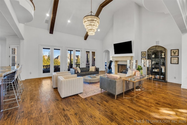 living room with beamed ceiling, hardwood / wood-style floors, a notable chandelier, and high vaulted ceiling