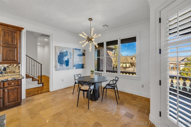 dining room with a notable chandelier and crown molding