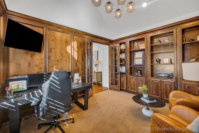 office area featuring high vaulted ceiling, wooden walls, and light colored carpet