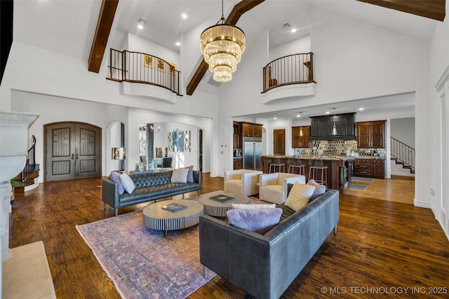 living room with beamed ceiling, high vaulted ceiling, dark wood-type flooring, and an inviting chandelier