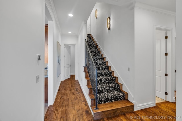 stairway featuring crown molding and hardwood / wood-style floors