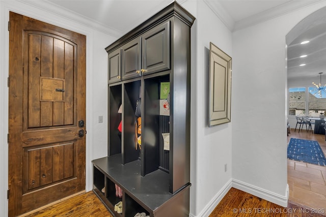 mudroom with a notable chandelier, ornamental molding, and dark hardwood / wood-style floors