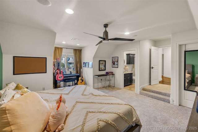 bedroom featuring connected bathroom, light colored carpet, and ceiling fan