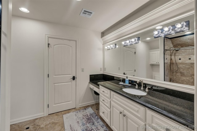 bathroom featuring a tile shower and vanity