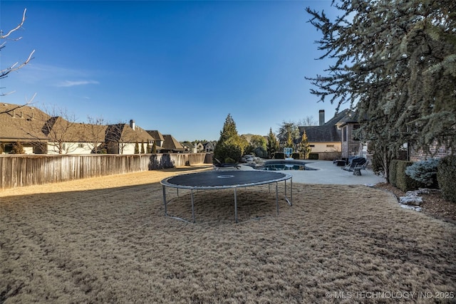 view of yard featuring a patio, a fenced in pool, and a trampoline