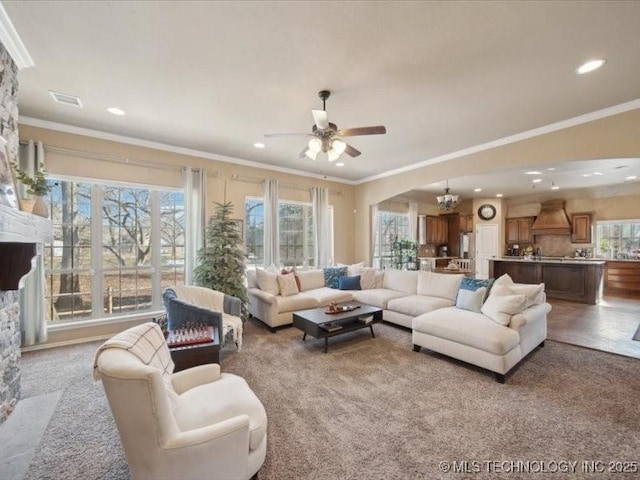 living room with ceiling fan with notable chandelier and ornamental molding