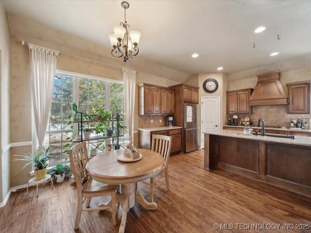 dining room with hardwood / wood-style flooring, sink, and an inviting chandelier