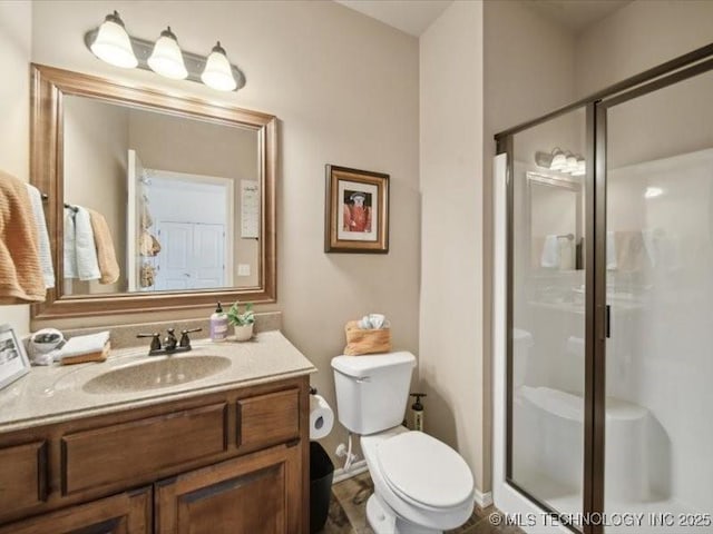 bathroom featuring a shower with door, vanity, and toilet