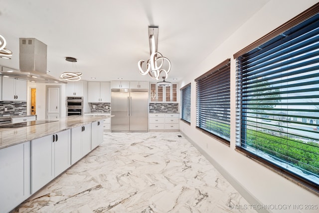 kitchen featuring white cabinetry, decorative light fixtures, and stainless steel appliances