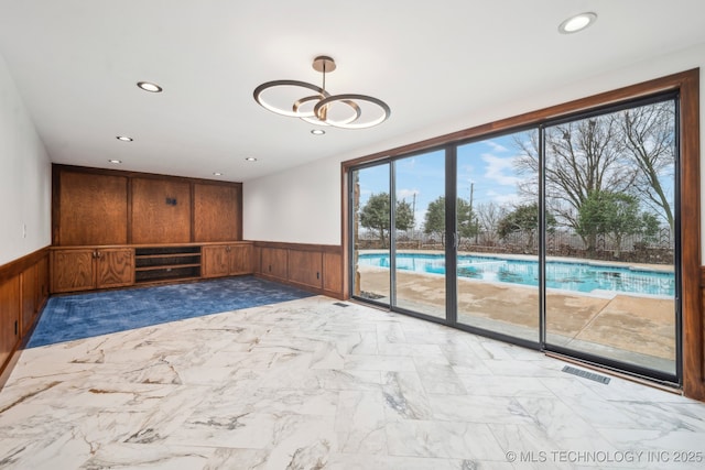 6642 E 60th Pl, Tulsa, OK 74145 - empty room featuring wainscoting, recessed lighting, a chandelier, wood walls, and marble finish floors