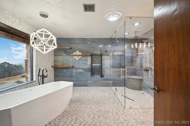 6642 E 60th Pl, Tulsa, OK 74145 - bathroom with a stall shower, a freestanding tub, a chandelier, and a towel warmer