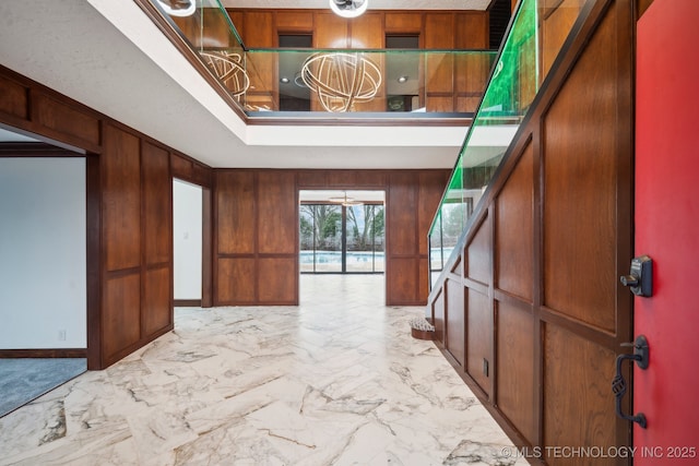 foyer entrance featuring wood walls