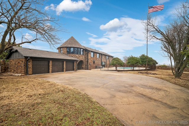 view of front facade featuring a pool, a garage, and a front yard