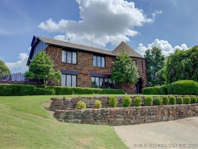6642 E 60th Pl, Tulsa, OK 74145 - view of front of property with board and batten siding, a front yard, and brick siding