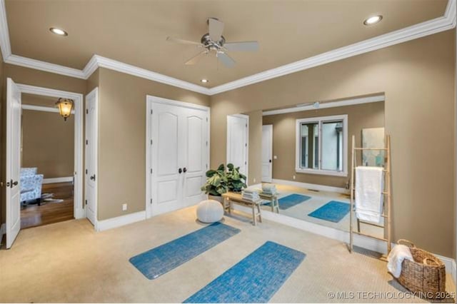 exercise area with crown molding, light colored carpet, and ceiling fan