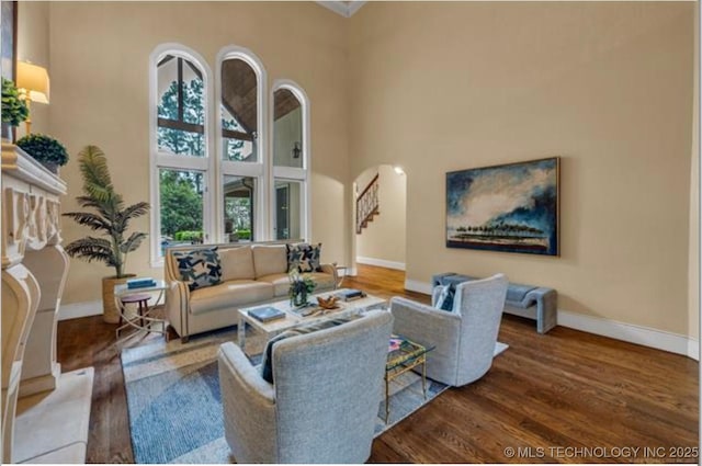 living room with hardwood / wood-style flooring and a towering ceiling