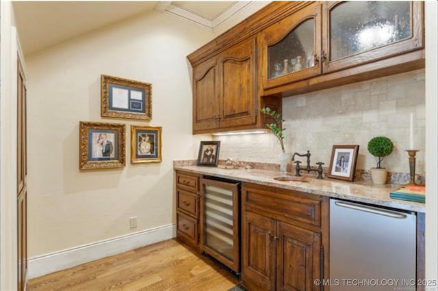 bar featuring sink, light hardwood / wood-style flooring, light stone counters, stainless steel dishwasher, and beverage cooler