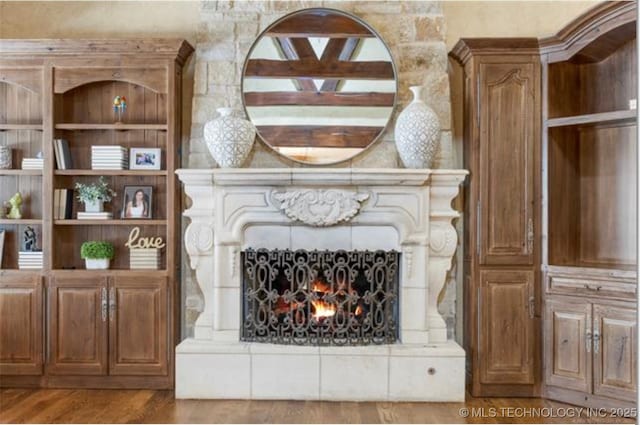 details with wood-type flooring and a large fireplace