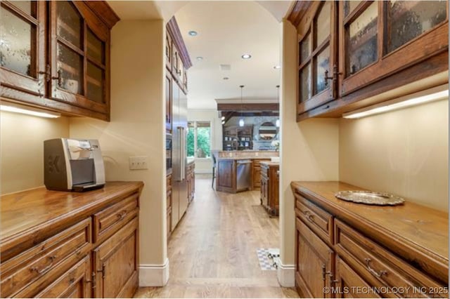 interior space with hanging light fixtures, light hardwood / wood-style flooring, and dishwasher