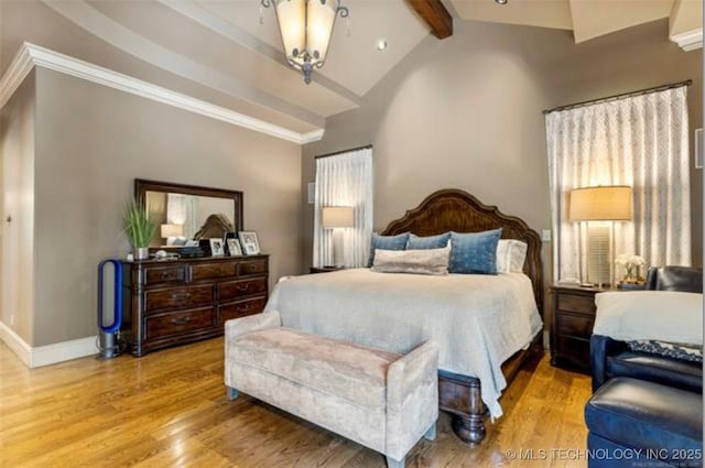 bedroom with lofted ceiling with beams and hardwood / wood-style floors