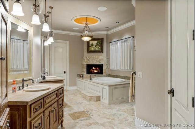 bathroom with vanity, a bathtub, crown molding, and a high end fireplace