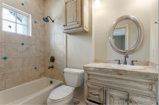 full bathroom with tiled shower / bath, vanity, and toilet