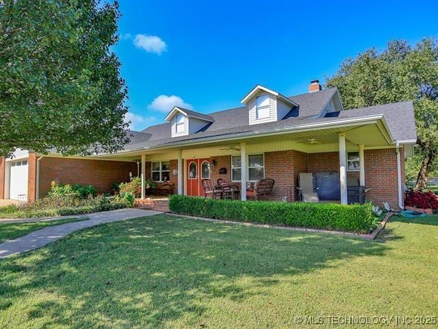 view of front of house with a garage, a front yard, and a porch