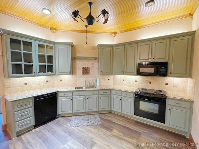 kitchen featuring sink, crown molding, tasteful backsplash, pendant lighting, and black appliances