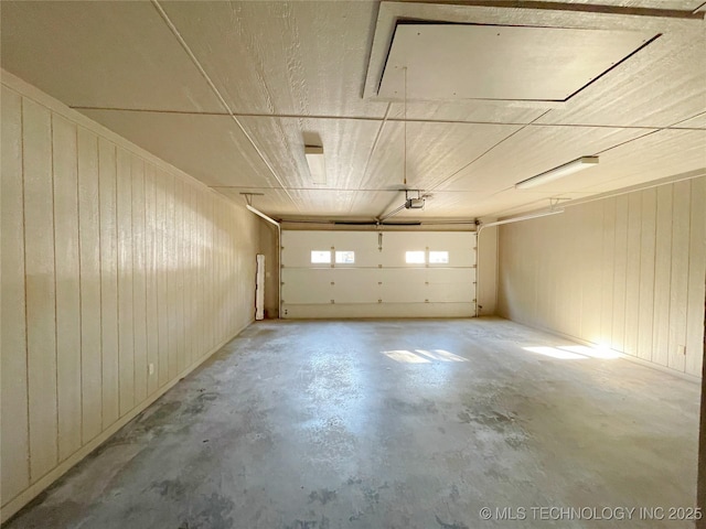 garage featuring a garage door opener and wood walls