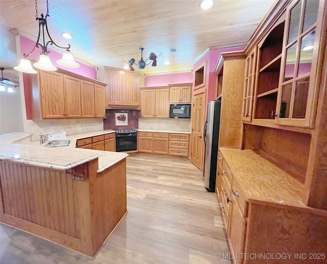 kitchen with hanging light fixtures, range with electric stovetop, stainless steel refrigerator, black microwave, and kitchen peninsula