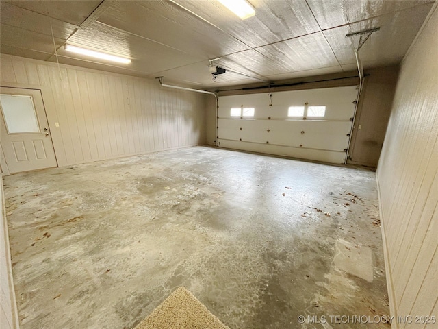 garage featuring a garage door opener and wood walls