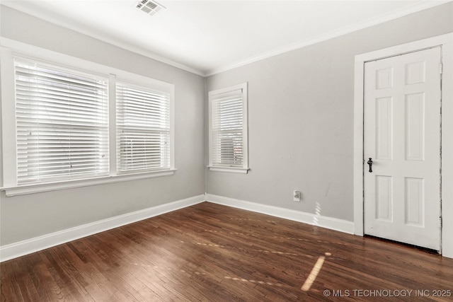 spare room featuring crown molding and dark hardwood / wood-style floors