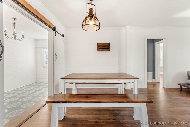 unfurnished dining area with crown molding, a barn door, and dark wood-type flooring