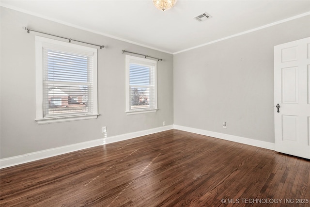 spare room with crown molding and dark wood-type flooring