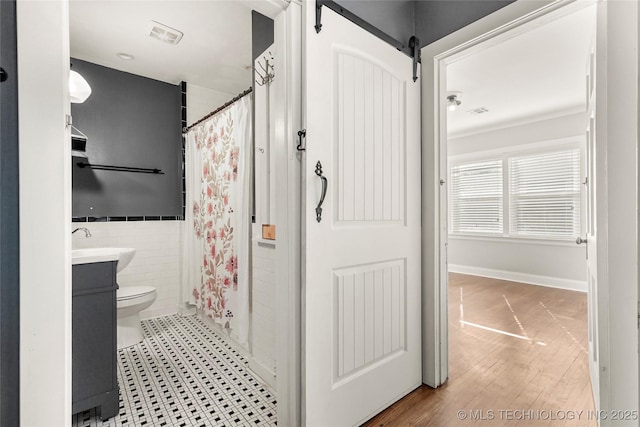 bathroom featuring vanity, curtained shower, toilet, and tile walls