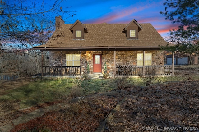 view of front facade featuring a porch, stone siding, and a chimney