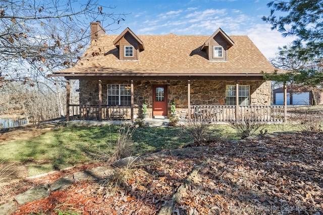 view of front of house with stone siding, a chimney, a porch, and roof with shingles