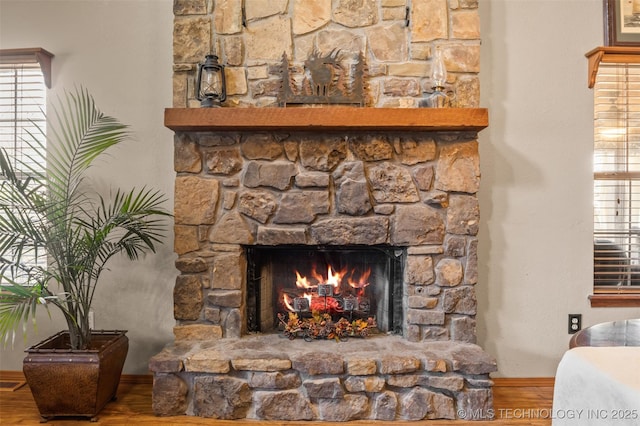 interior details with a stone fireplace and hardwood / wood-style floors