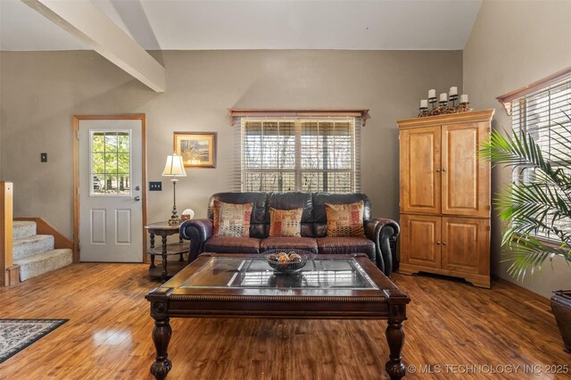 living room featuring vaulted ceiling with beams and hardwood / wood-style flooring