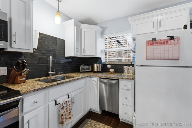 kitchen featuring sink, decorative light fixtures, stone counters, stainless steel appliances, and white cabinets