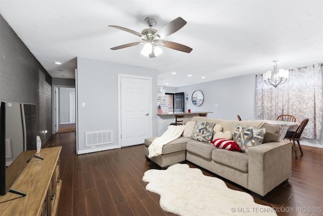 living room featuring ceiling fan with notable chandelier and dark hardwood / wood-style flooring