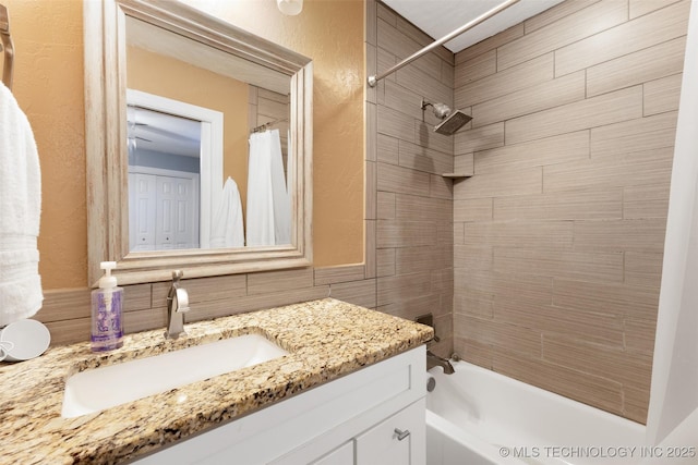 bathroom with vanity, tile walls, and shower / bath combo with shower curtain