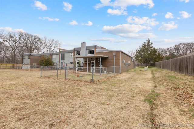 rear view of house featuring a lawn