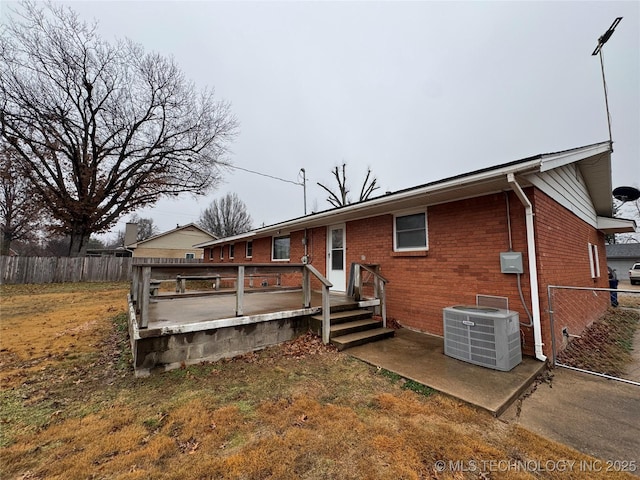 back of house with central AC unit and a wooden deck