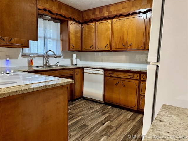 kitchen with sink, white appliances, backsplash, a textured ceiling, and dark hardwood / wood-style flooring