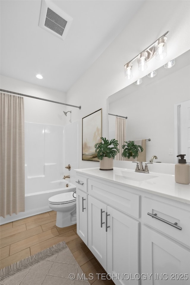 full bathroom featuring hardwood / wood-style flooring, vanity, shower / tub combo, and toilet