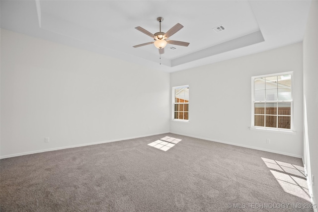 unfurnished room featuring light carpet, ceiling fan, and a tray ceiling