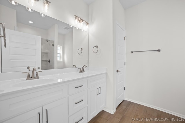 bathroom with hardwood / wood-style flooring, vanity, and a shower