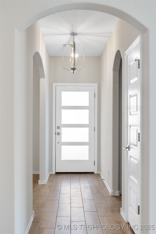 entryway featuring light tile patterned floors and a notable chandelier