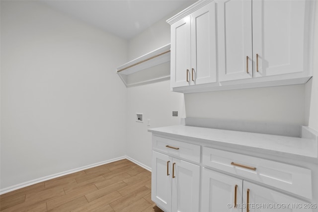 clothes washing area with cabinets, hookup for a washing machine, and light wood-type flooring